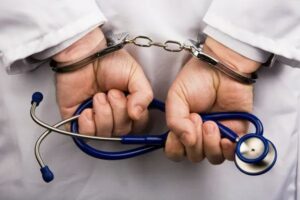 depositphotos_8140381-stock-photo-doctor-with-stethoscope-and-handcuffs_com